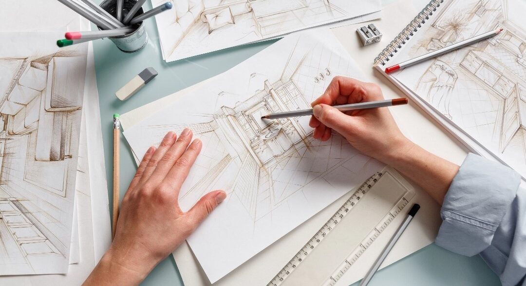 Hands drawing a room on a piece of paper