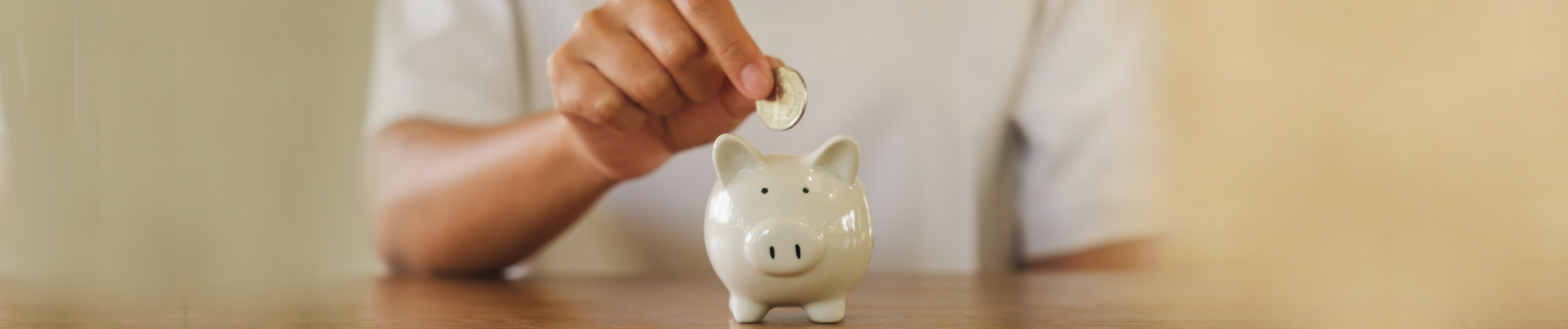 Hand, throwing a coin into the piggy bank