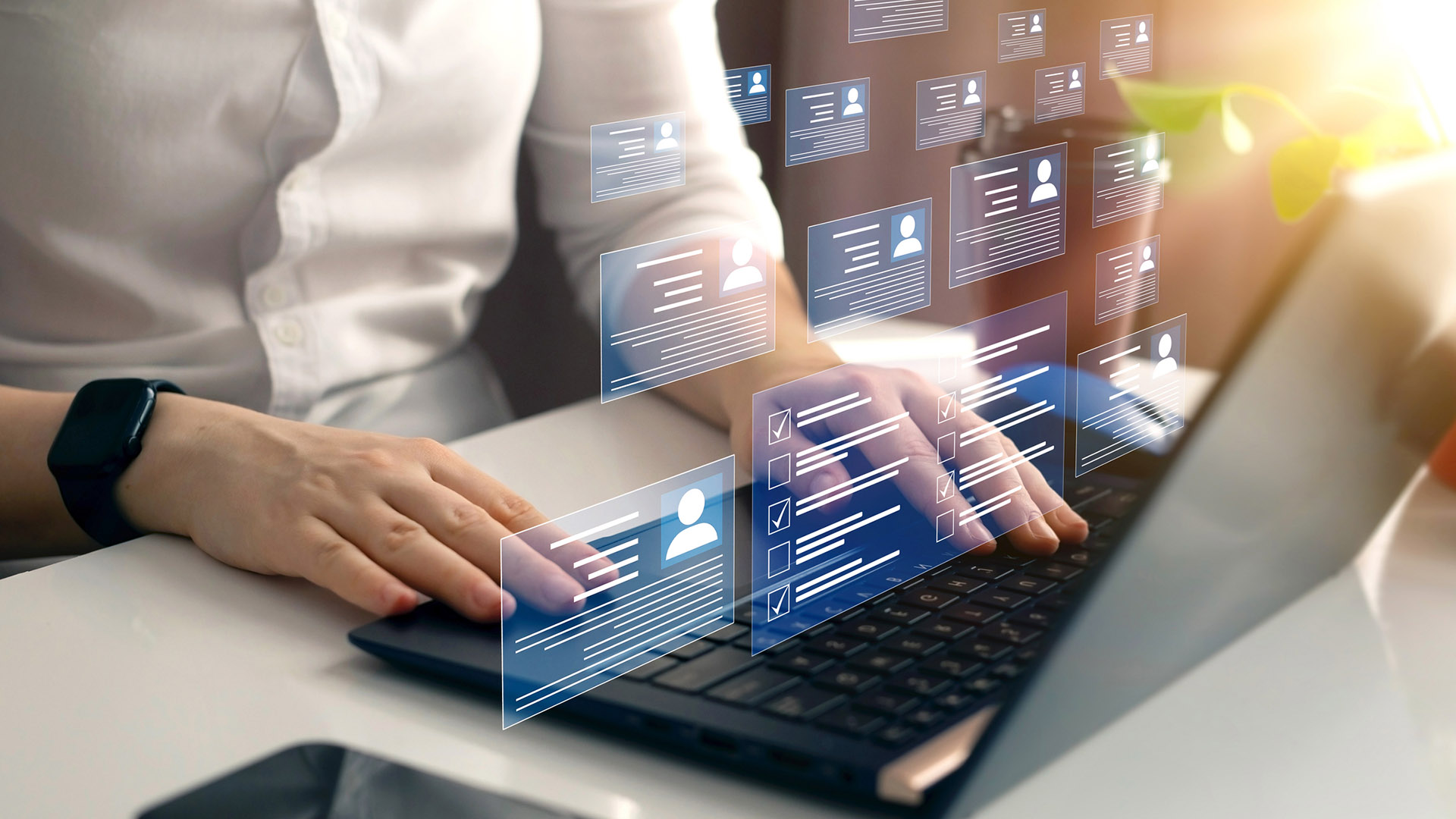 a fragment of a character using a laptop, with virtual business card graphics displayed above the keyboard