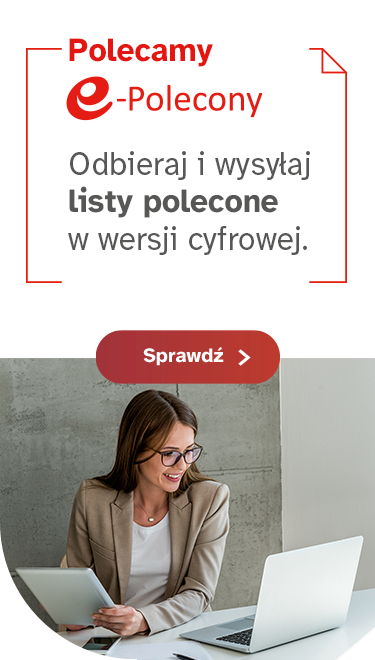 Młoda, uśmiechnięta kobieta w okularach pisze na laptopie.