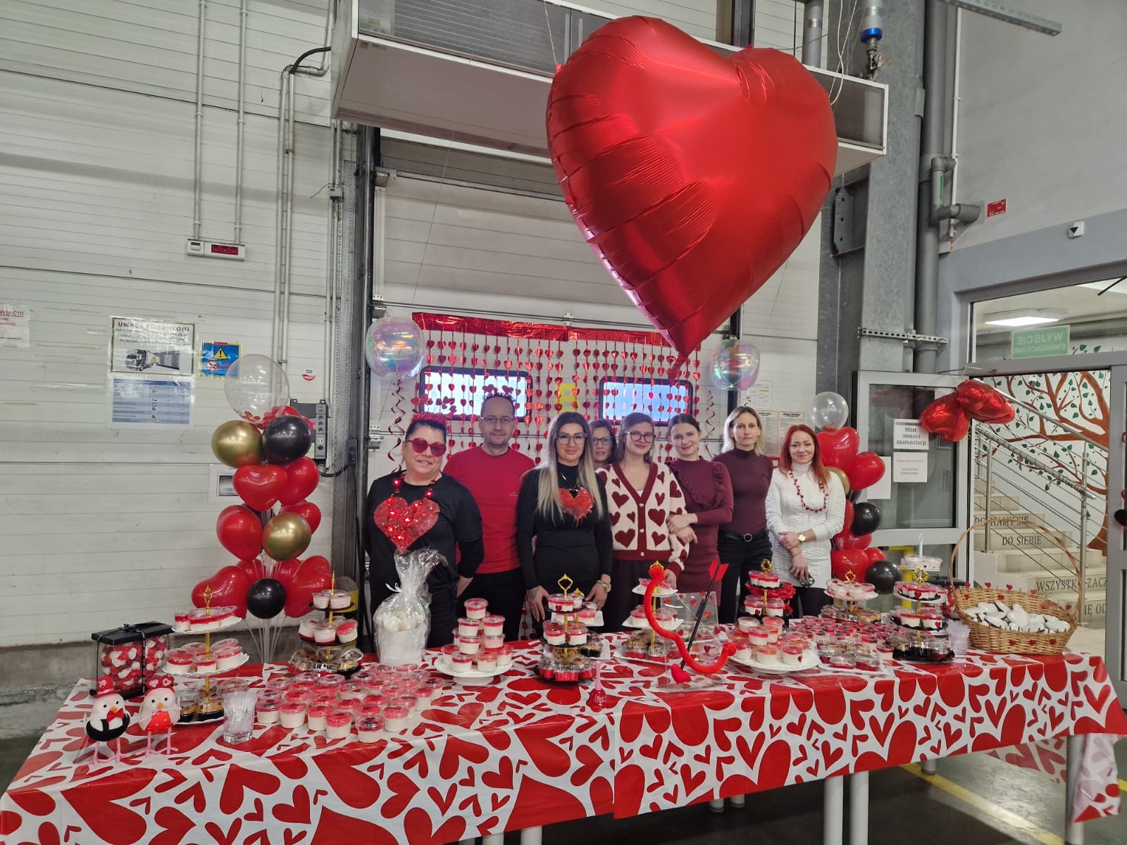 a group of people at a table covered with decorations in Valentine's Day costumes