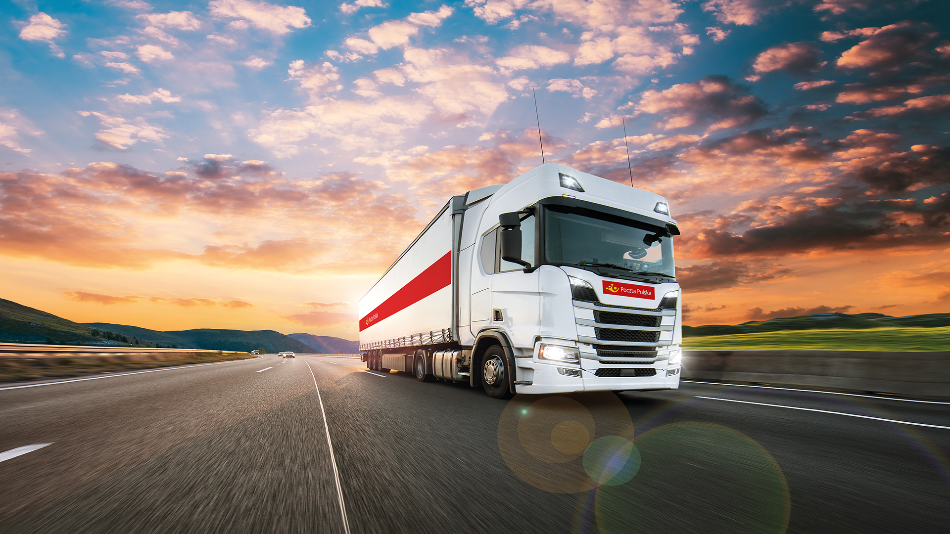 ciężarówka na tle zachodzącego słońca z logo Poczta Polska