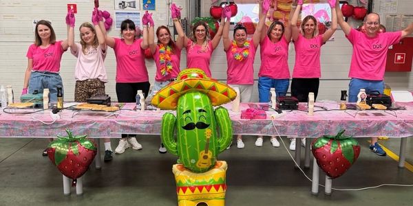 a group of cheerful people in pink T-shirts